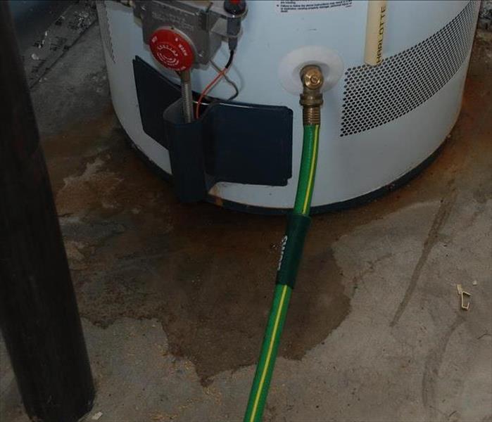 shows water leaking from underneath the water heater 